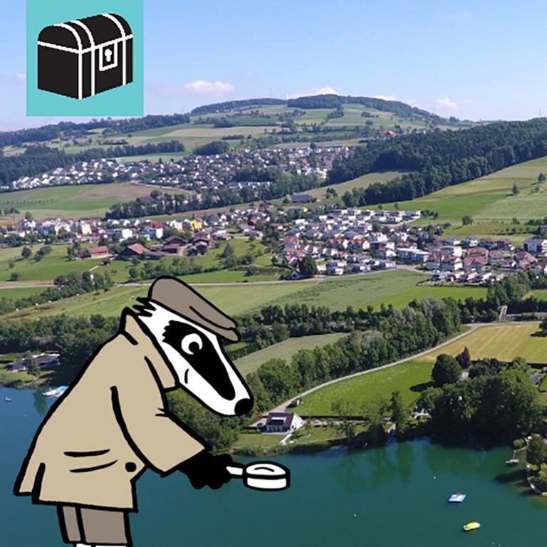 detektiv-trail-schenkon-innerschweiz-Sempachersee-Weinberg-Kunst im Kreisel-Wanderweg Erlebe die Detektiv-Trails mit Detektiv Dachs: Ein spannendes Rätselerlebnis für Jung und Alt. Du begibst dich auf eine Entdeckungstour durch Schenkon in der wunderschönen Region Innerschweiz. Der Trail führt dich auf den in die Natur bis zum idyllischen Sempachersee. Unterwegs hast du herrliche Ausblicke auf Wasser, Wiesen und Berge. Du entdeckst spannende Kunst im Kreisel, geniesst die Ruhe der Natur und kommst sogar an einem kleinen, gepflegten Weinberg vorbei. Die abwechslungsreiche Route verbindet Natur, Kultur und Rätselspass auf unterhaltsame Weise. Immer wieder eröffnen sich dir neue Perspektiven auf den See und die umliegende Landschaft, während du knifflige Aufgaben löst und Schenkon aus einer ganz neuen Sicht kennenlernst. Der Detektiv-Trail Schenkon bietet eine harmonische Mischung aus Rätsellösen, Bewegung und Naturgenuss perfekt eingebettet in die malerische Kulisse des Sempachersees. Perfekt für Familien, Kinder, Schulklassen, Grosseltern und alle, die gerne draussen unterwegs sind. Viel Vergnügen auf deinem Rätselabenteuer!